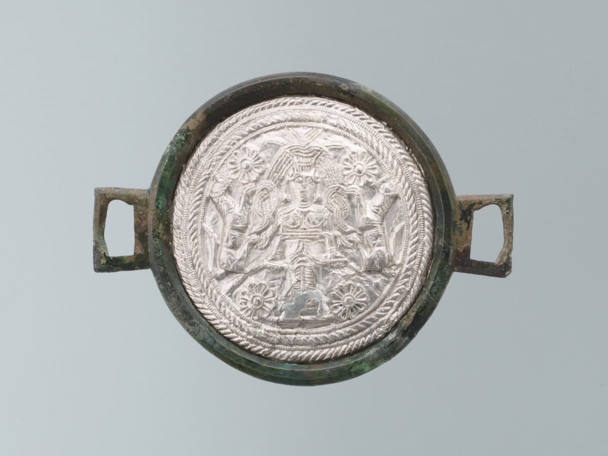 Drei antike Silbermedaillons mit komplizierten Mustern, jedes in einem runden Bronzerahmen mit zwei rechteckigen Griffen eingefasst, vertikal ausgestellt.