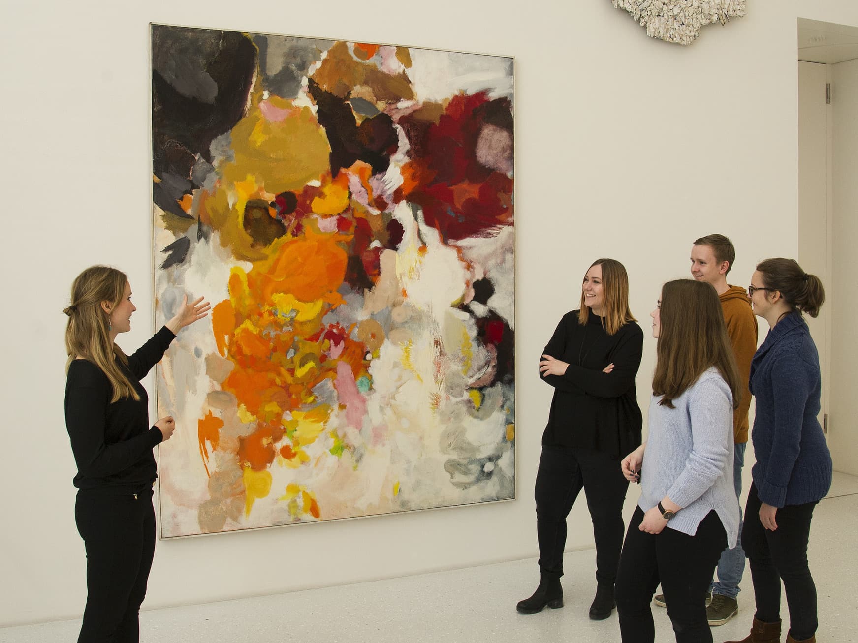 Besuchergruppe sieht sich moderne Kunst an.