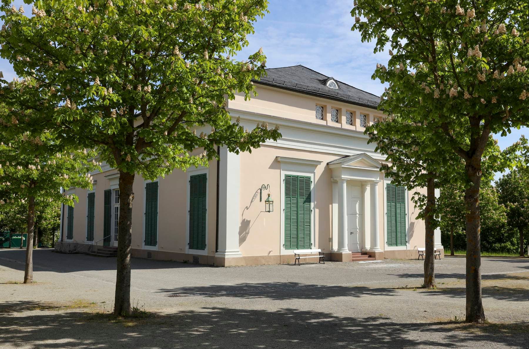 Außenansicht des Ballhauses mit Bäumen im Vordergrund