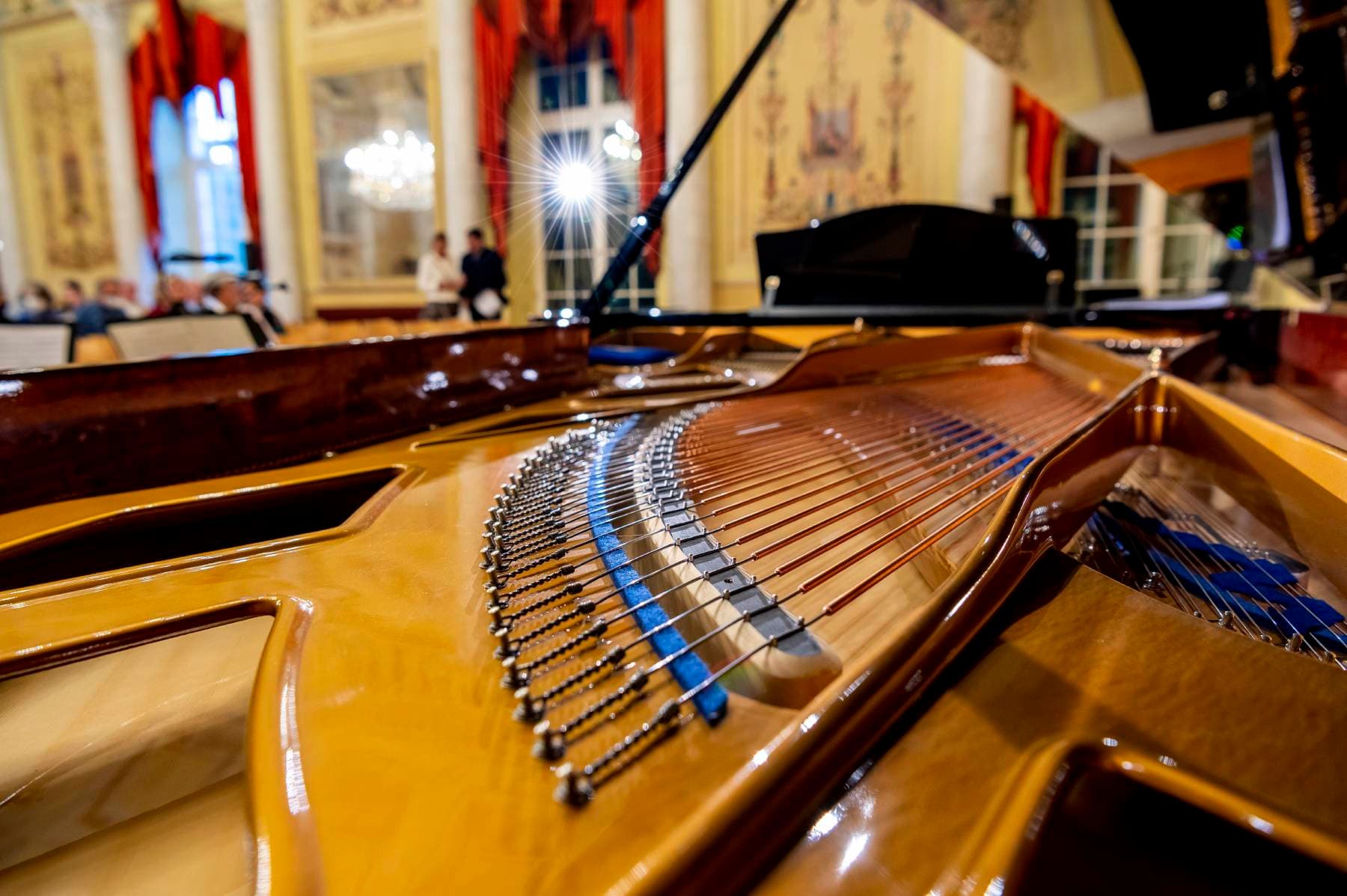 Blick in den Konzertflügel, im Hintergrund verschwommen der Ballsaal