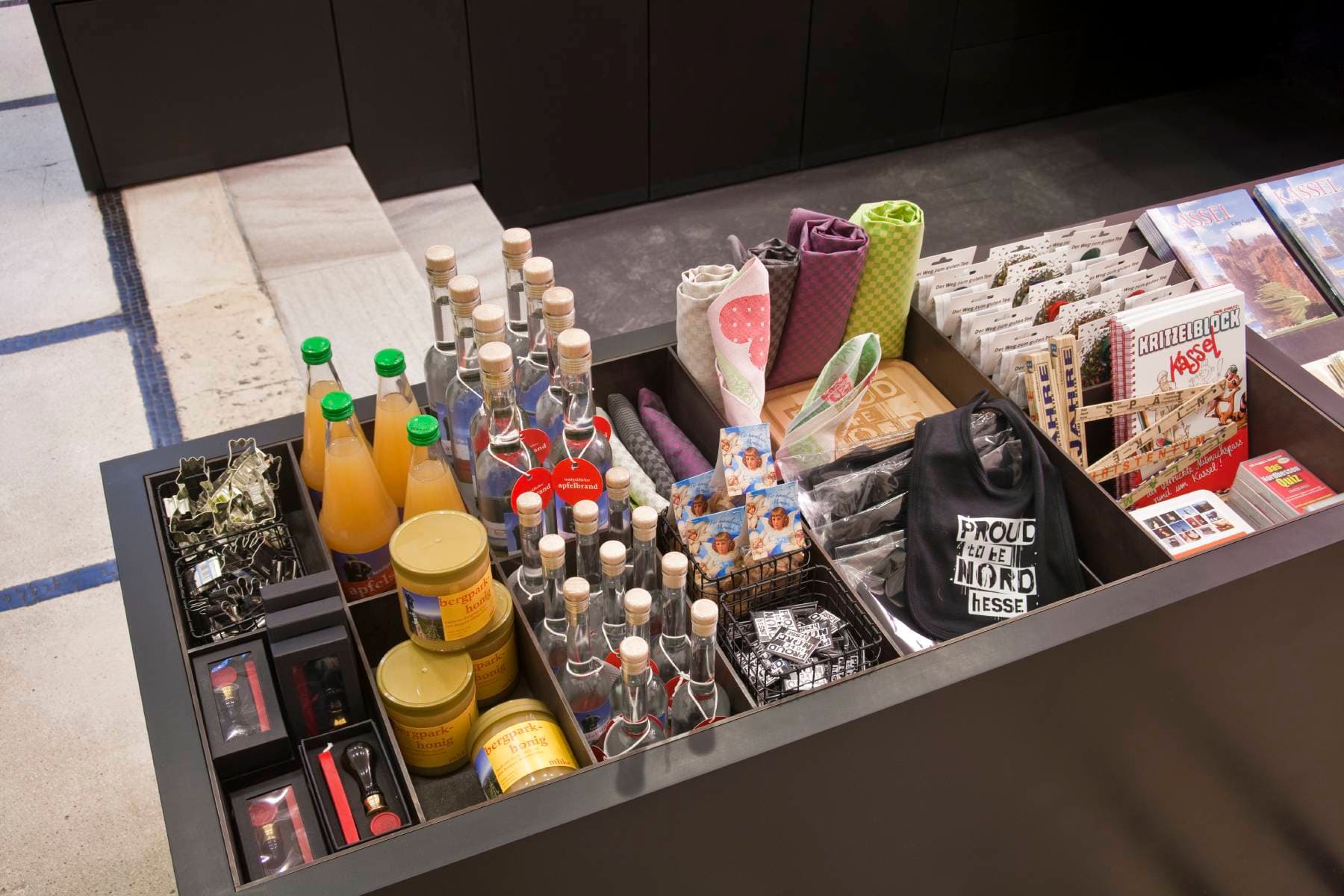 Shopartikel, wie z.B. Honig, Apfelsaft und Schnaps aus dem Bergpark, sowie Geschirrhandtücher, Plätzchenausstecher und Malblöcke