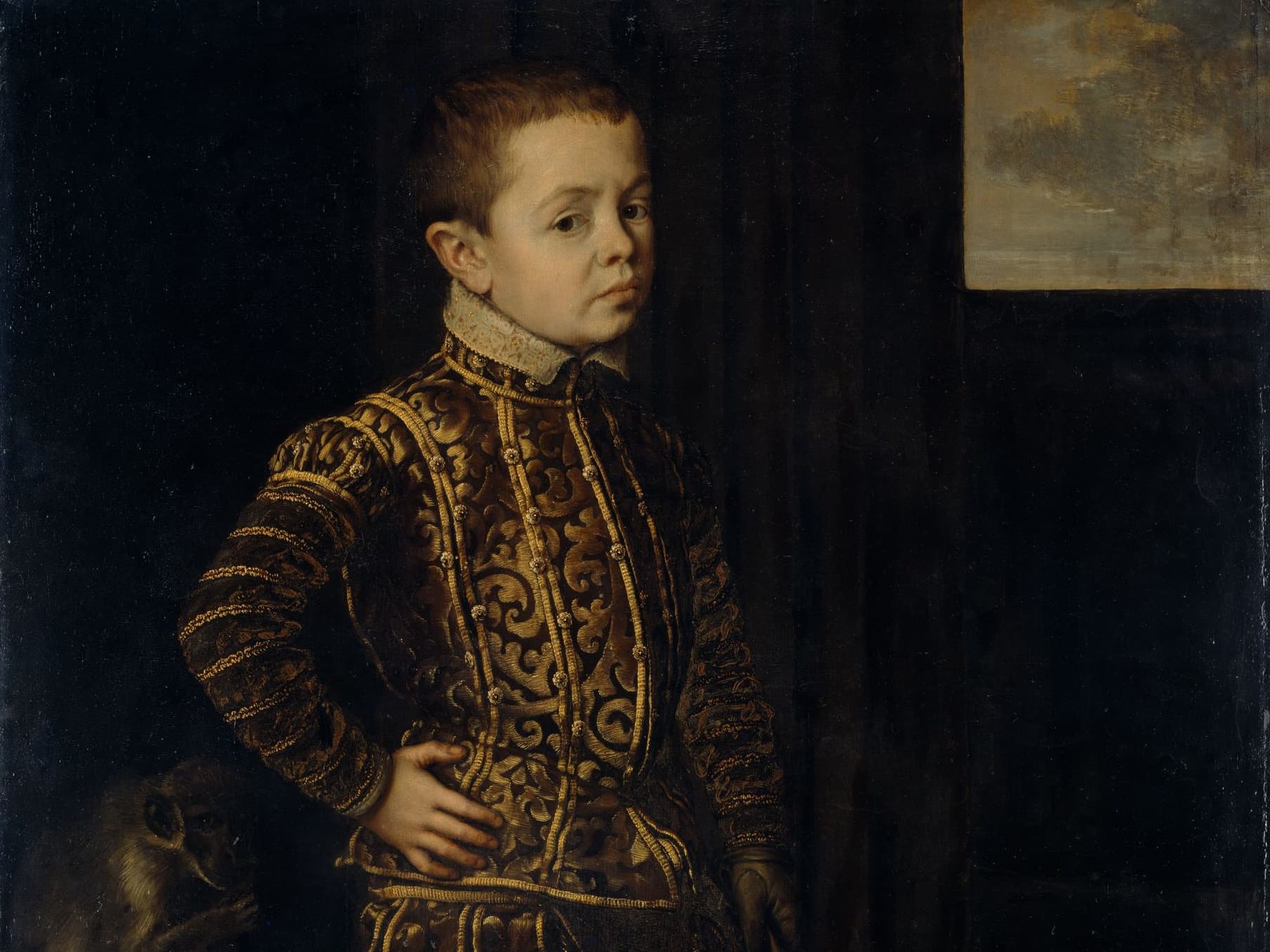 Ein kleiner Junge in reich verzierter Renaissance-Kleidung steht mit einer Hand auf der Hüfte und blickt vor einem dunklen Hintergrund zur Seite.