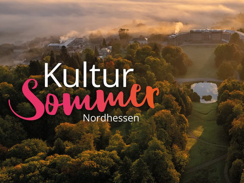 Aerial view of a foggy landscape with trees and a pond at sunrise, featuring the text "Kultur Sommer Nordhessen."