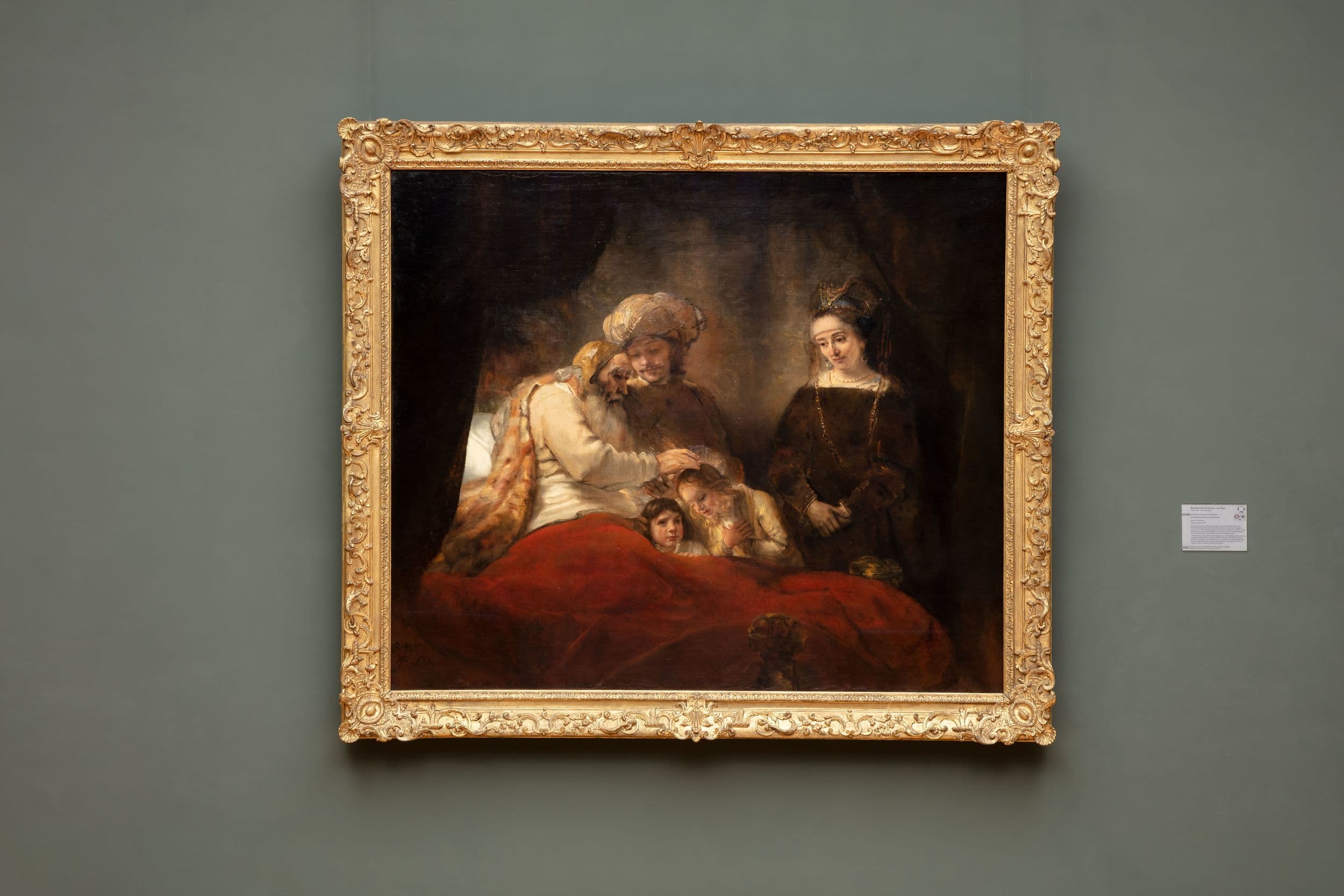 Alter Mann im Bett hält die Hand über den Kopf eines von zwei Kindern.