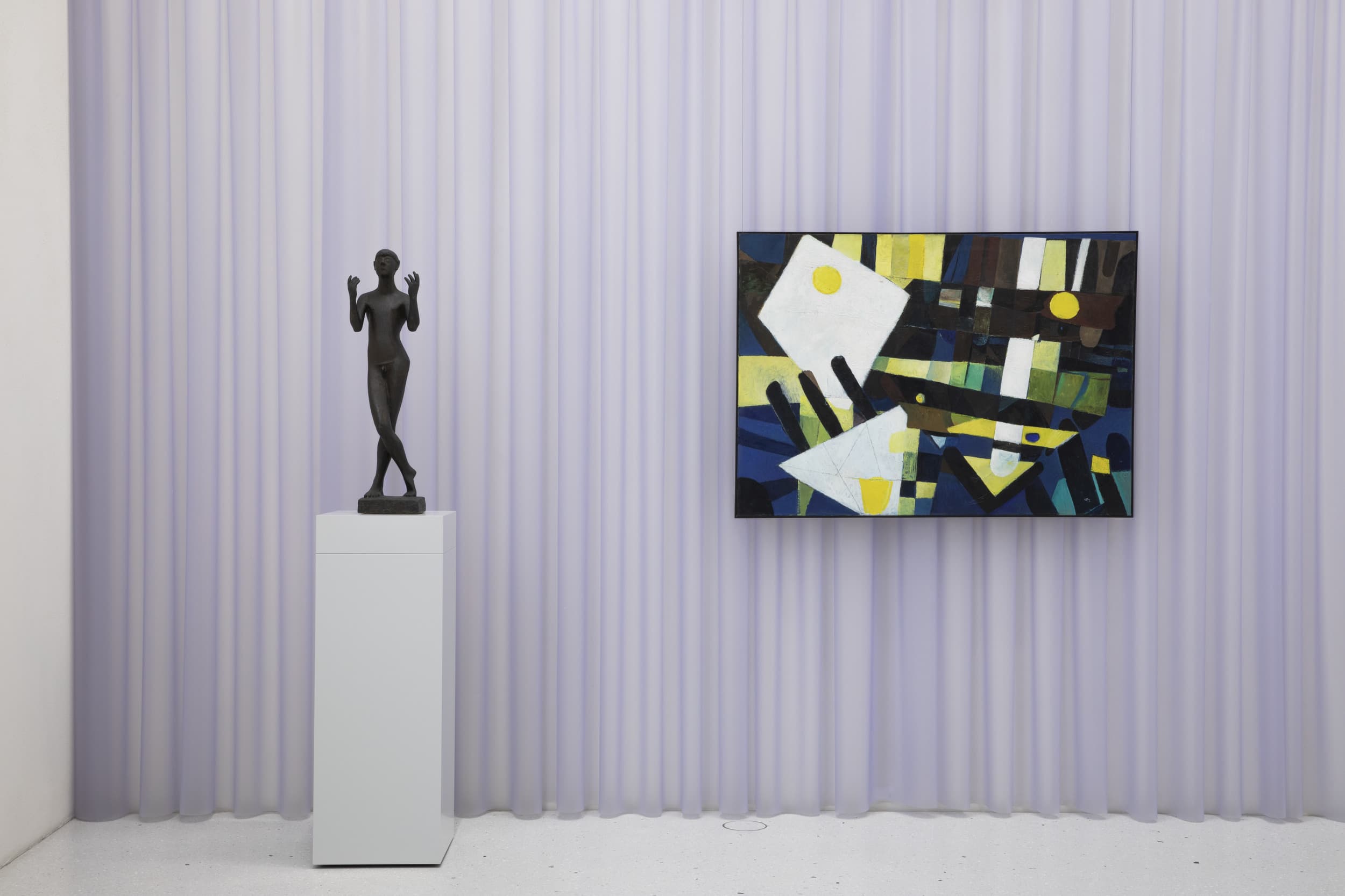 Eine moderne Kunstgalerie mit einer schwarzen abstrakten Skulptur auf einem Sockel und einem farbenfrohen geometrischen Gemälde an der Wand vor einem hellvioletten Vorhang im Hintergrund.