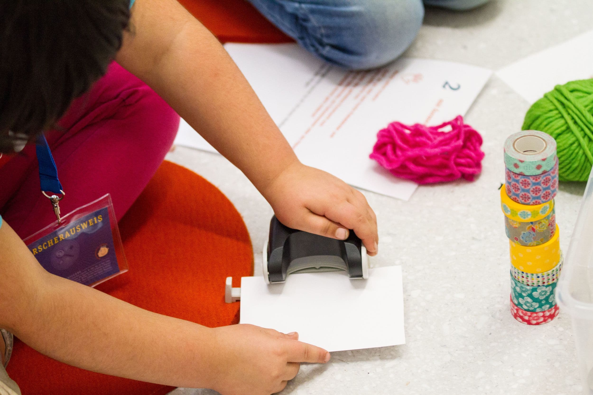 Kind benutzt einen Locher.