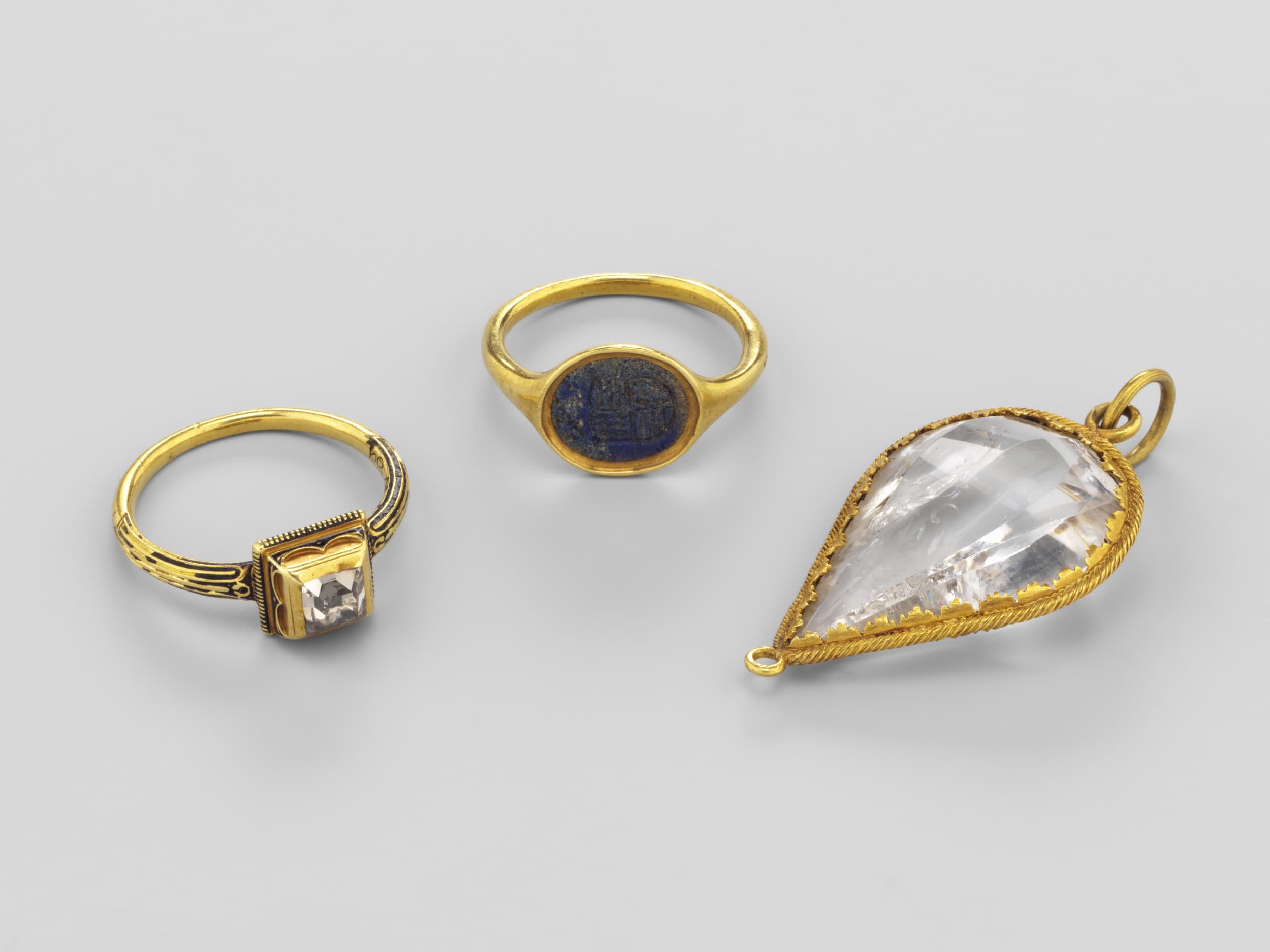 Drei Schmuckstücke, darunter zwei Goldringe, einer mit Diamant besetzt, der andere mit eingesetztem Schmuckstein, außerdem ein in Gold eingefasster Diamant-Anhänger