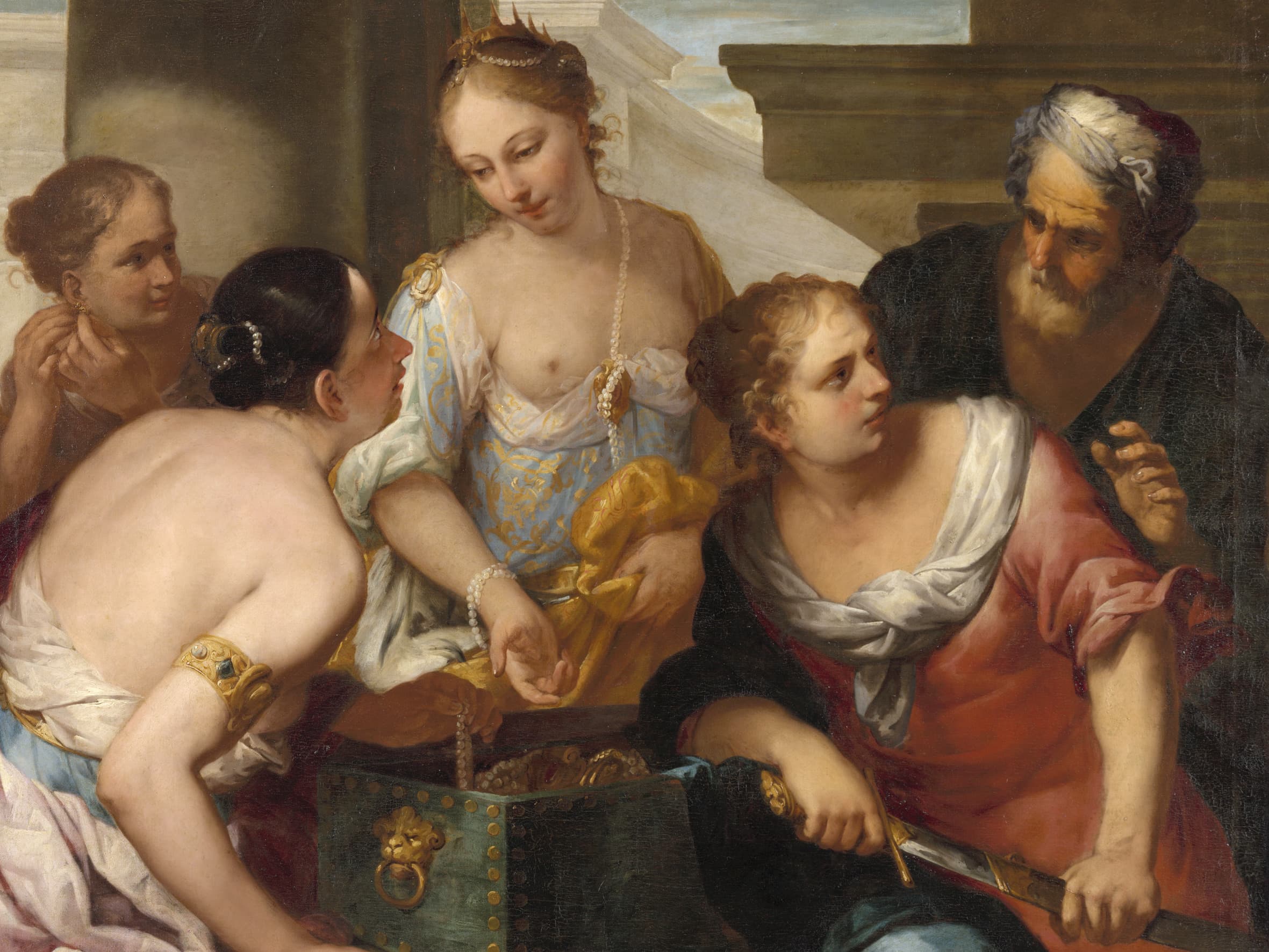 Eine Gruppe von Menschen in historischer Kleidung versammelt sich um eine offene, mit Gold gefüllte Truhe und unterhält sich.