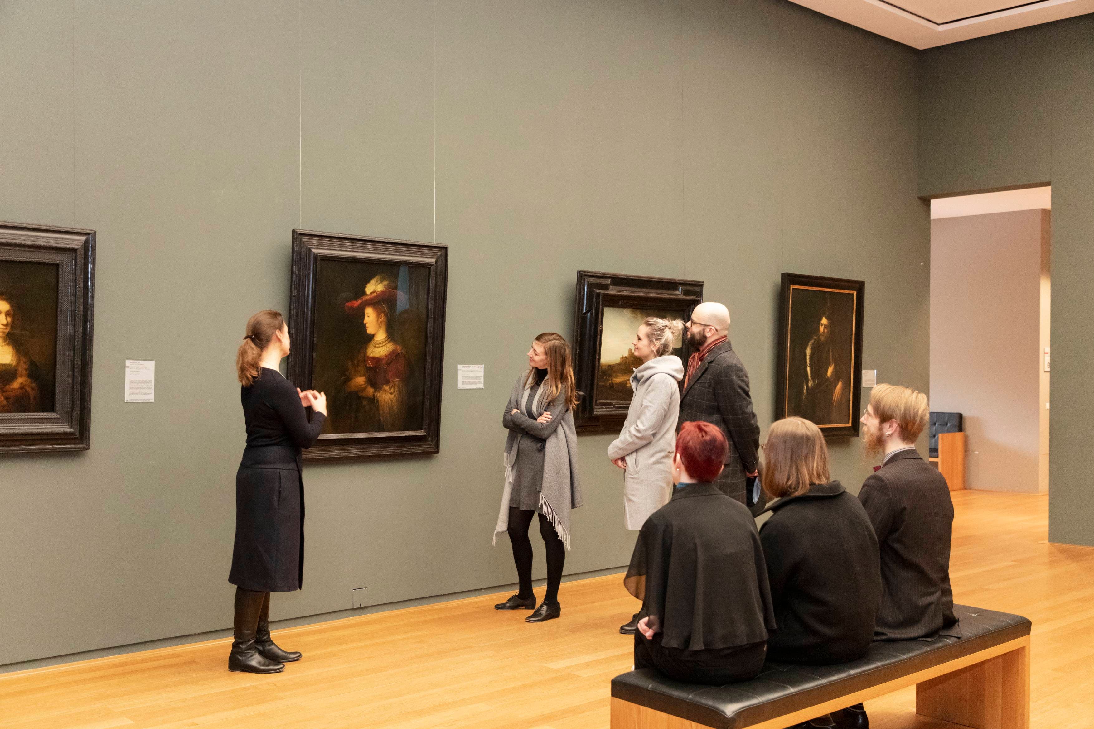 Eine kleine Menschengruppe, die sich mit einer Führung das Gemälde der Saskia von Rembrandt anschauen.