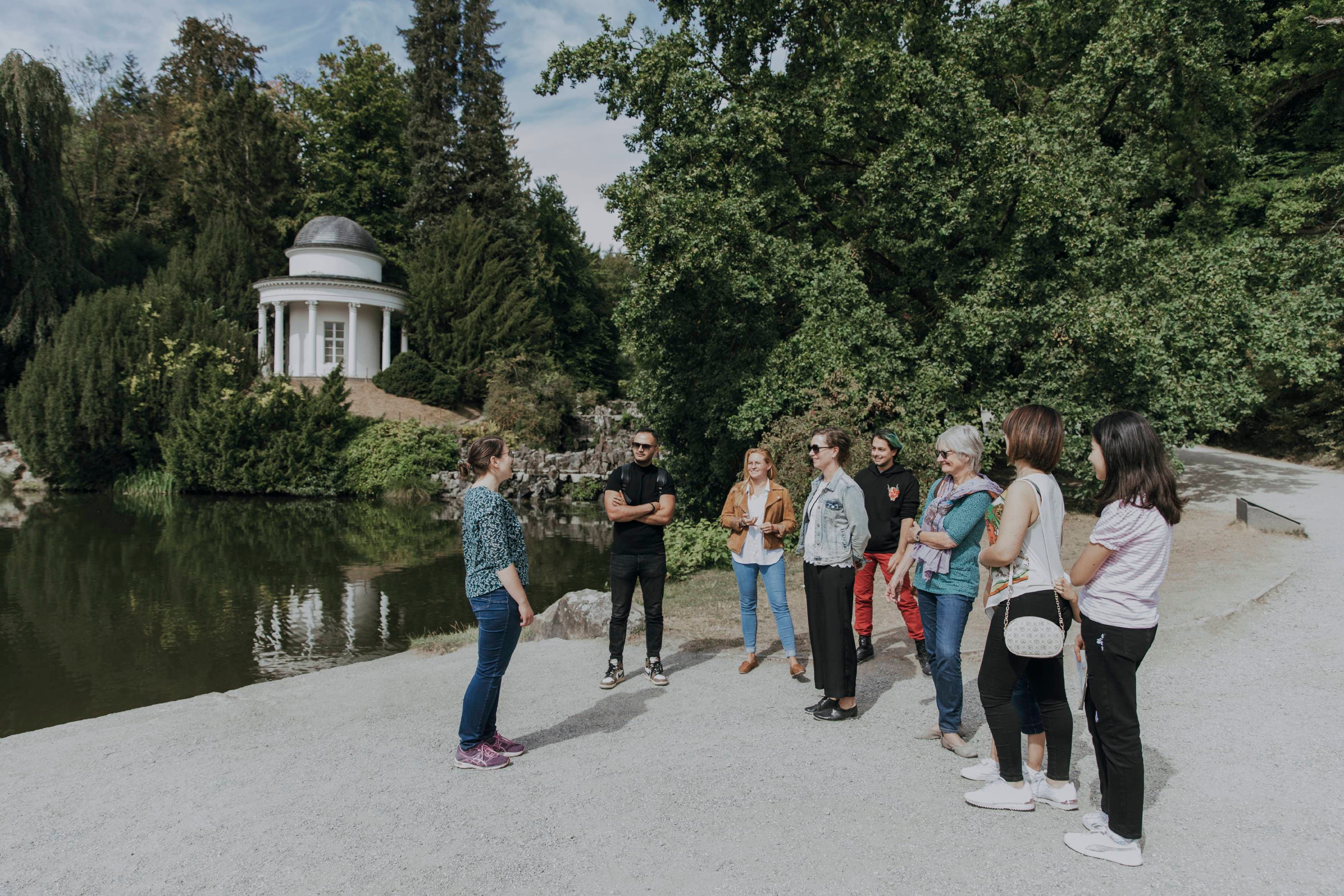 Eine kleine Menschengruppe, die mit einer Führung den Bergpark besuchen
