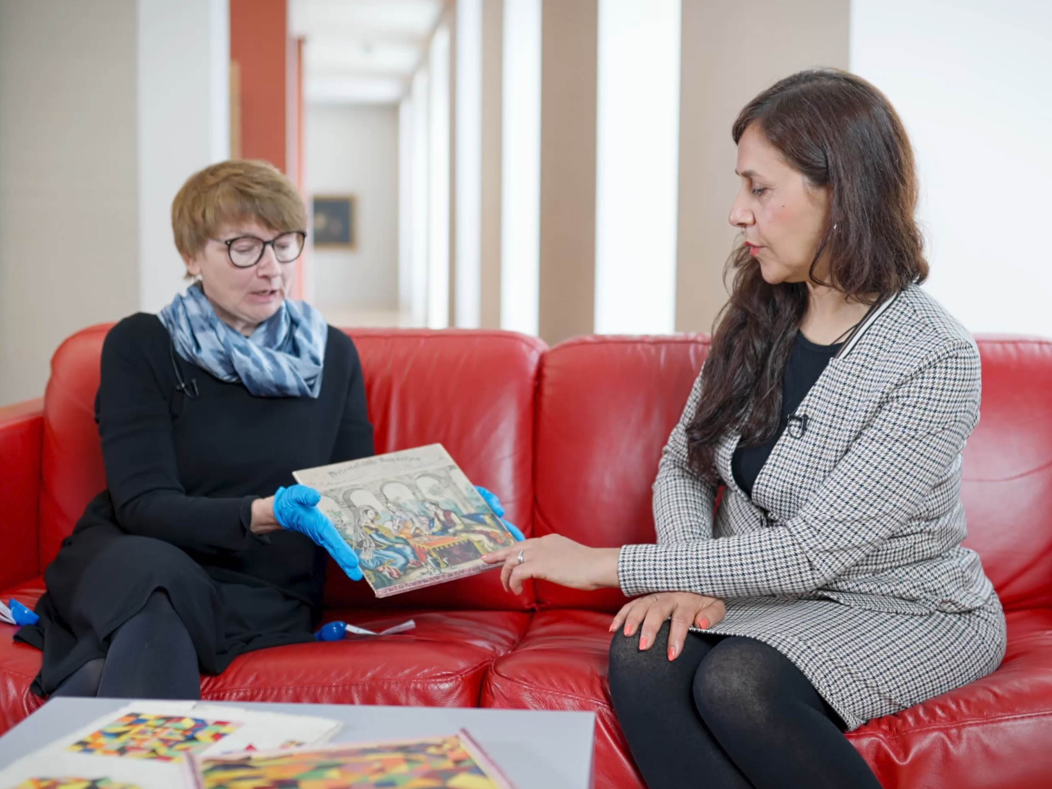 Text: Spielkultur im 19. Jahrhundert. Orientalisches Parquetspiel. Bild: Dr. Martina Lüdicke und Touran Mohsenipour betrachten ein Prequetspiel