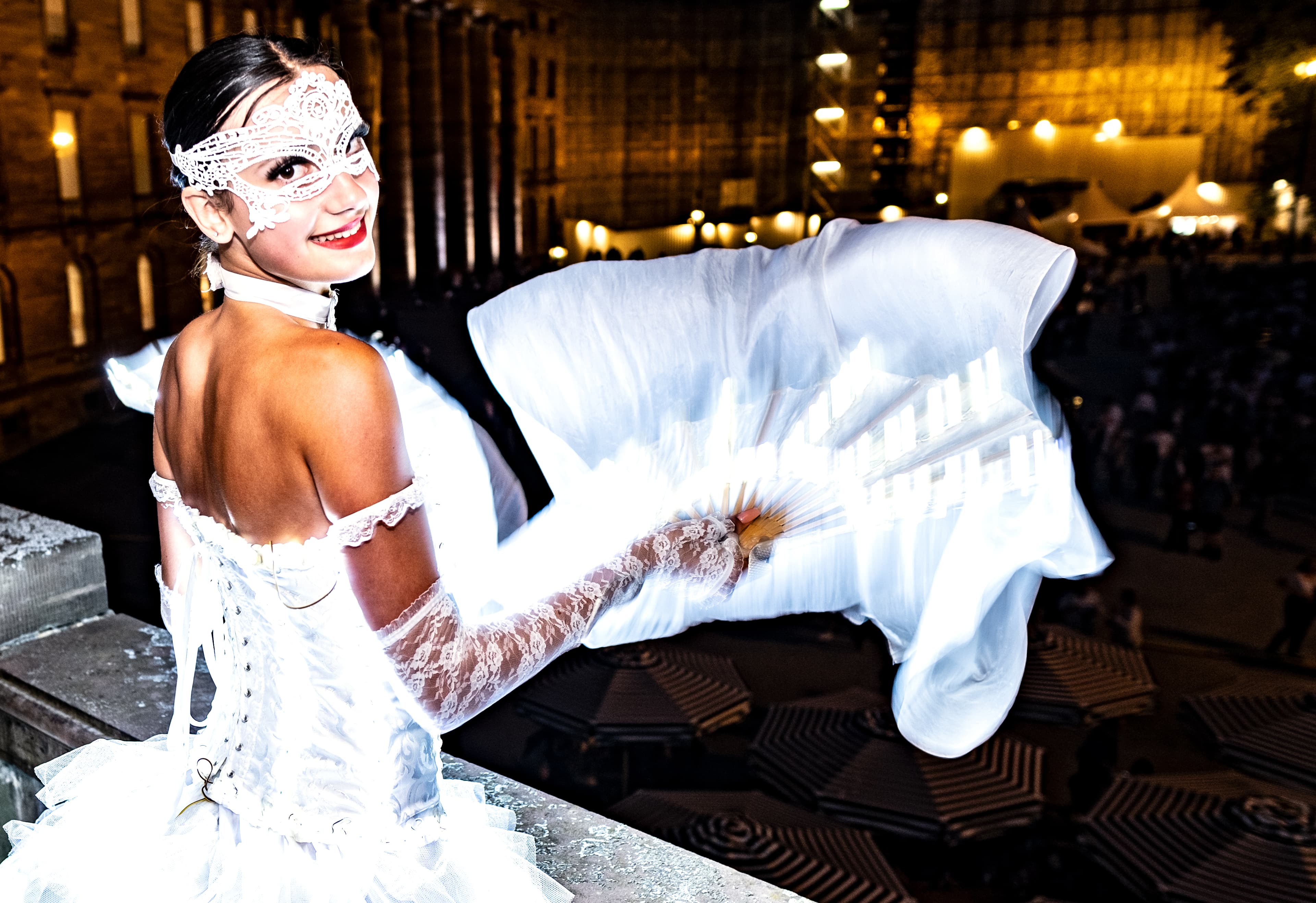 Lächelnde Frau in weißem Kleid vor Schloss Wilhelmshöhe.