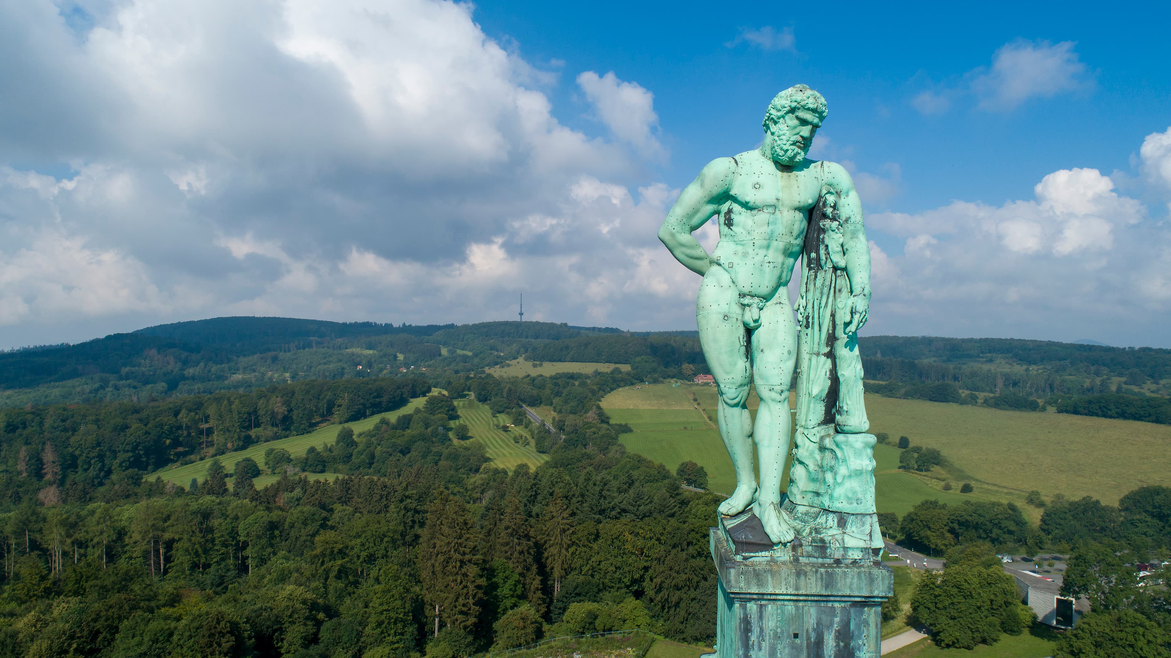 Nahaufnahme des Kasseler Herkuls, im Hintergrund der Habichtswald aus der Vogelperspektive