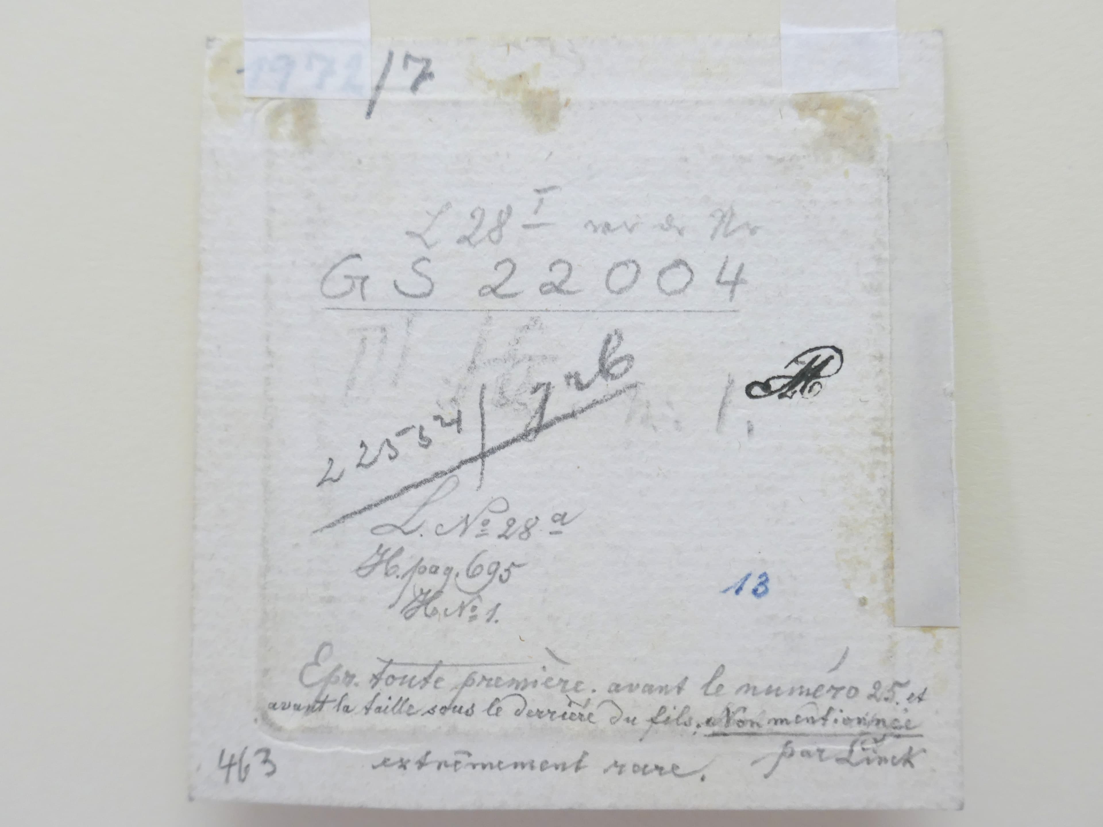 Rückseite eines Gemäldes mit handschriftlichen Notizen, Nummern und Markierungen. An den Ecken ist Klebeband sichtbar und die Oberfläche weist Gebrauchsspuren auf.